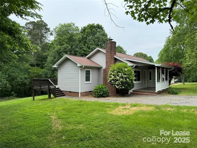 a view of a house with a yard and tree s