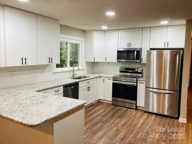 a kitchen with a sink a microwave a refrigerator and cabinets