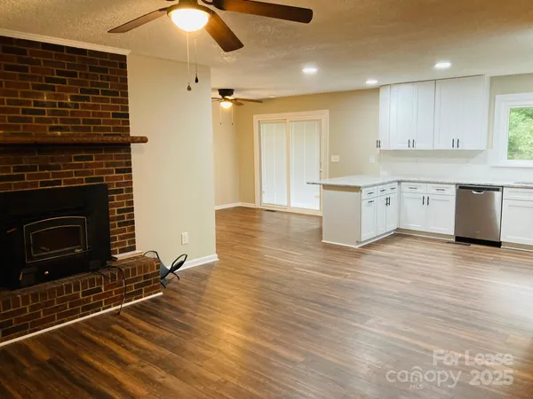 a kitchen with granite countertop a stove cabinets and wooden floor