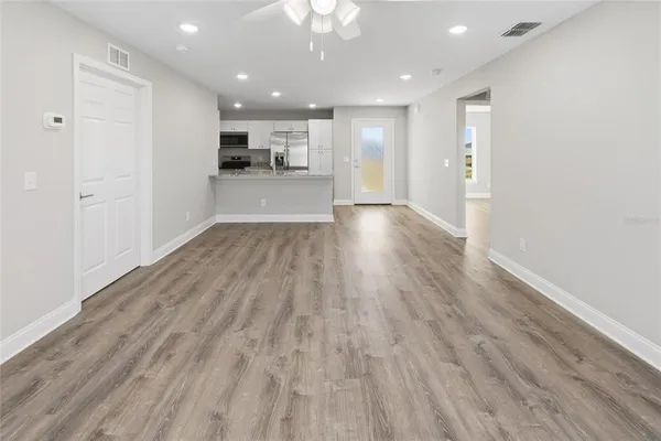 a view of a kitchen with wooden floor and a window