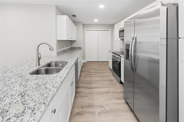 a kitchen with kitchen island a sink stove and refrigerator