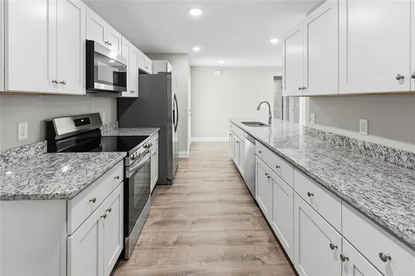 a kitchen with granite countertop sink stainless steel appliances and cabinets