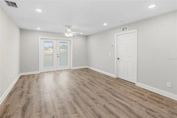 a view of an empty room with wooden floor