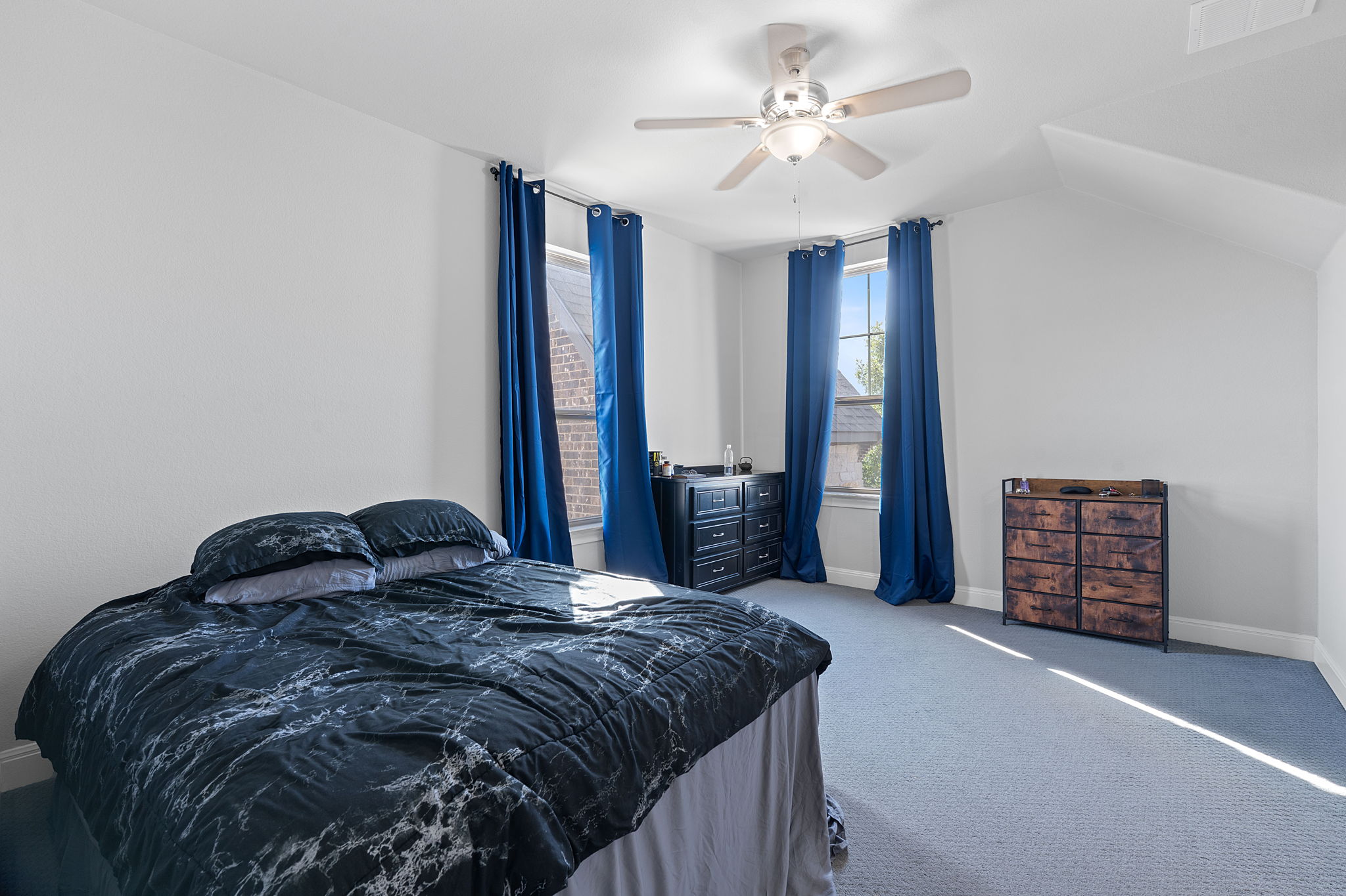 4212 Borho Ranch Street Leander, TX 78641 - Photo 22 of 29 a bedroom with a bed a dresser and a chandelier