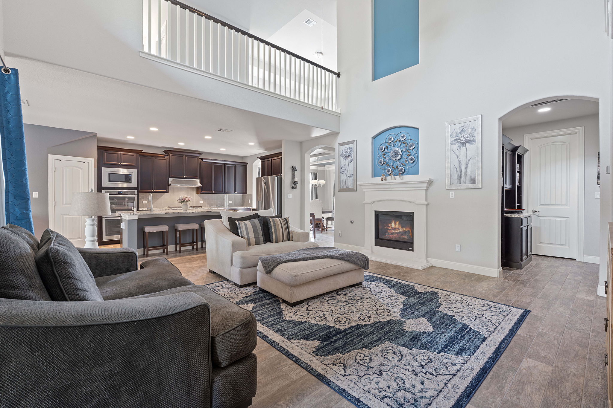 4212 Borho Ranch Street Leander, TX 78641 - Photo 6 of 37 Living room featuring recessed lighting, arched walkways, light wood finished floors, a high ceiling, and a glass covered fireplace