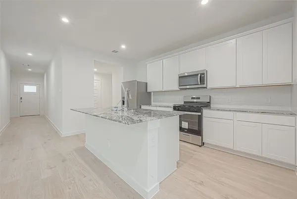 a close view of kitchen stove sink and cabinets