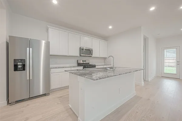 a kitchen with stainless steel appliances granite countertop a refrigerator and a sink