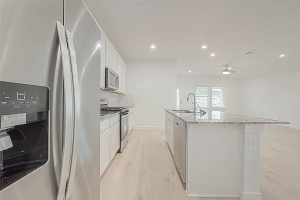 a kitchen with stainless steel appliances granite countertop a sink and a stove