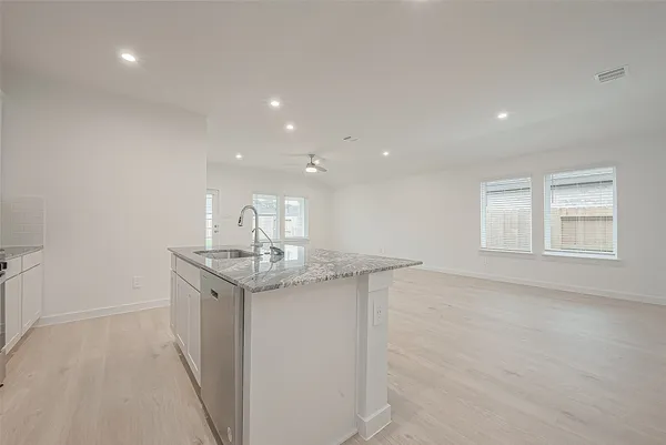 a kitchen with stainless steel appliances granite countertop a sink stove and cabinets