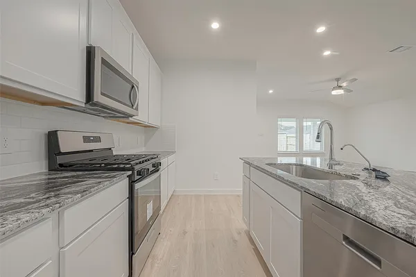 a kitchen with stainless steel appliances granite countertop a stove and a sink