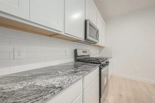 a kitchen with stainless steel appliances granite countertop a stove and a microwave