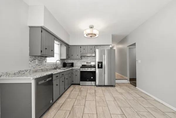 a kitchen with stainless steel appliances granite countertop a stove cabinets and refrigerator