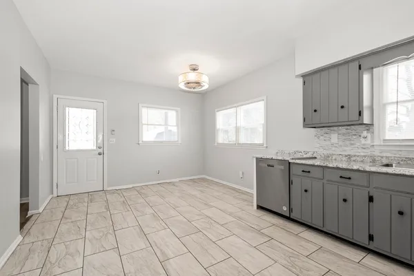an empty room with windows and cabinet