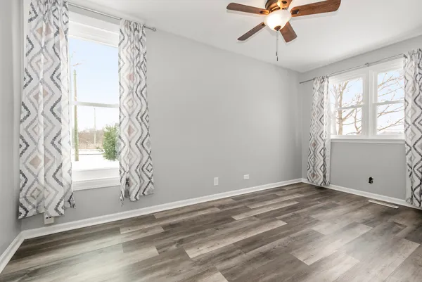 a view of wooden floor and chandelier fan in a room