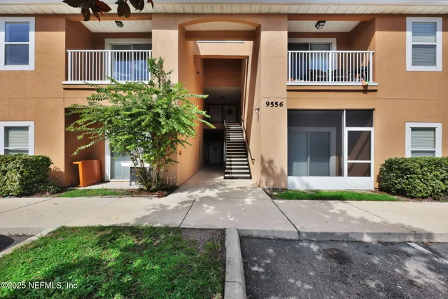 a view of a brick house with a yard and plants