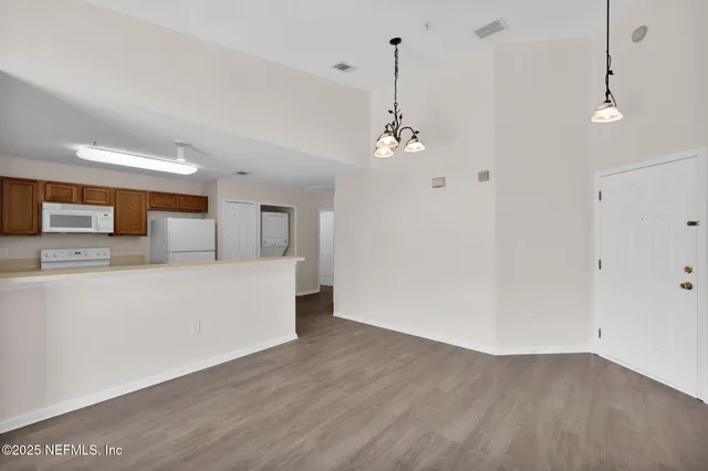 a view of a kitchen with stainless steel appliances a wooden floor