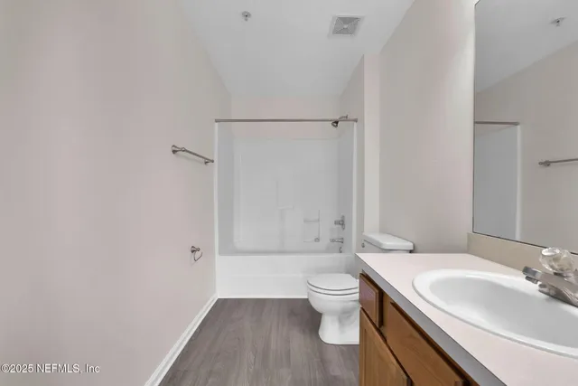 a bathroom with a granite countertop sink toilet a large mirror and shower