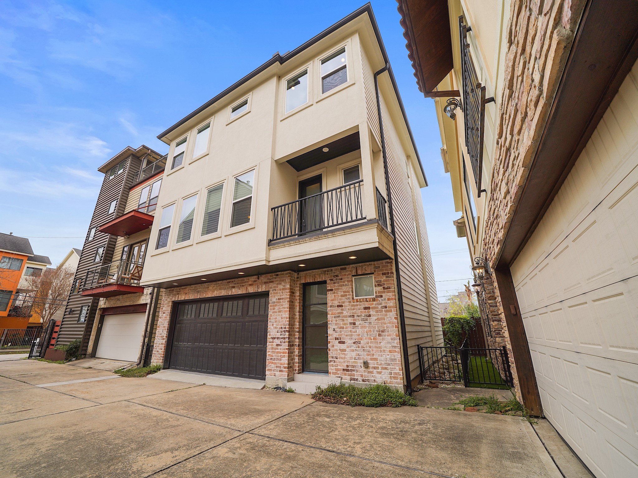 Modern three-story, 4 bedroom, 3.5 bathroom home in the heart of Rice Military, featuring a gated driveway, contemporary façade, and private access.
