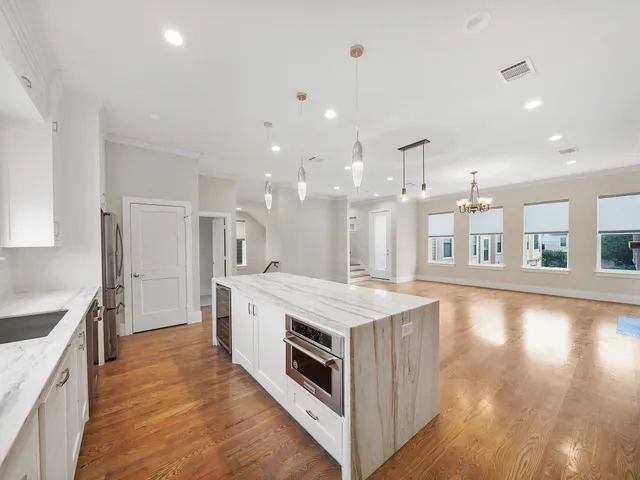 a large kitchen with stainless steel appliances a large counter top and a stove