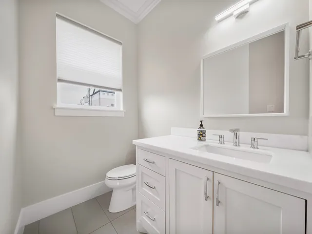 a bathroom with a toilet a sink a vanity and mirror