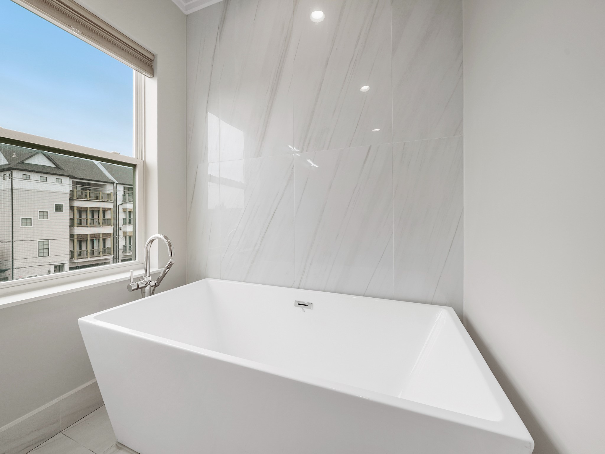 1512 Thompson Street, Unit 2 Houston, TX 77007 - Photo 28 of 39 Spa-inspired soaking tub with oversized tile backdrop and natural light—perfect for unwinding at home.