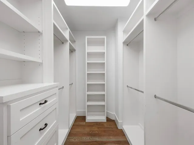 a view of walk in closet with empty racks