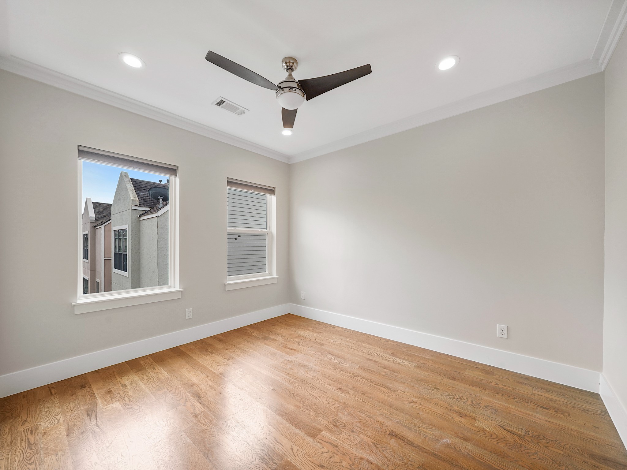 1512 Thompson Street, Unit 2 Houston, TX 77007 - Photo 37 of 39 Additional third-floor bedroom with ceiling fan and wood flooring, ideal for guests or a home office.