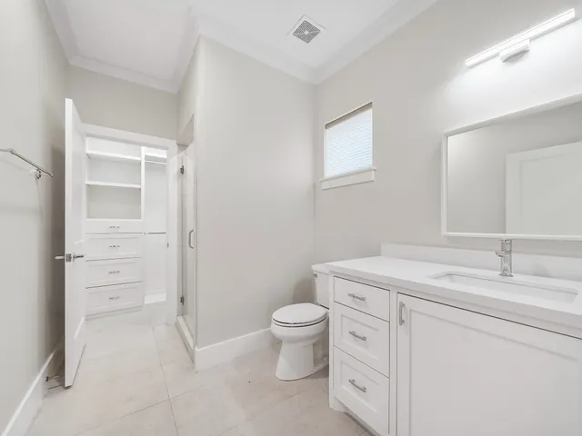 a spacious bathroom with a granite countertop sink a toilet and a mirror