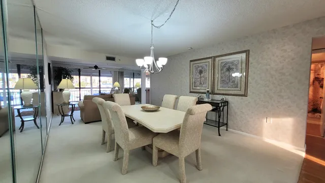 a dining room with furniture a chandelier and window