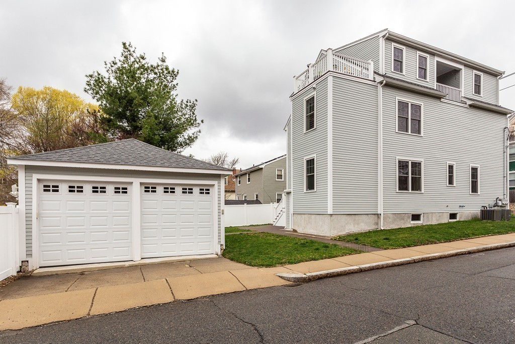 40 Catherine Street, Unit 2 Boston, MA 02131 - Photo 21 of 26 a front view of a house with a yard and garage
