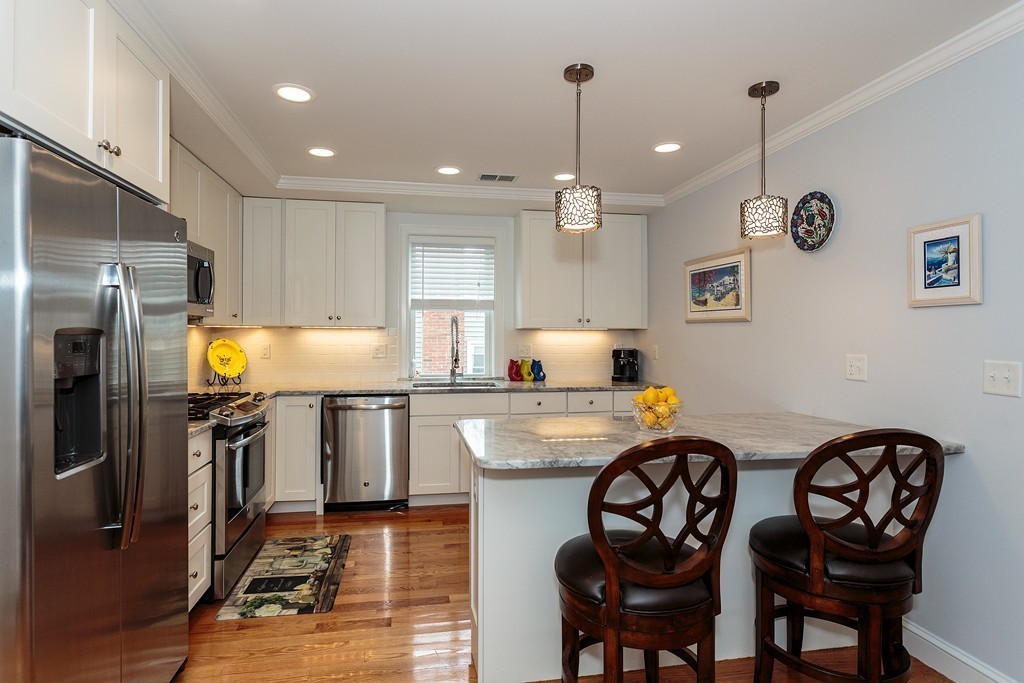 40 Catherine Street, Unit 2 Boston, MA 02131 - Photo 3 of 26 a kitchen with stainless steel appliances granite countertop a sink a stove a refrigerator cabinets and chairs