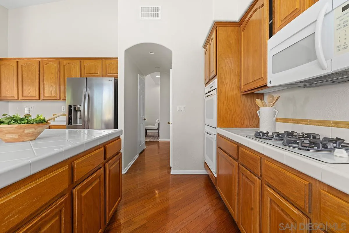 987 Palencia Court Chula Vista, CA 91910 - Photo 24 of 70 a kitchen with stainless steel appliances granite countertop a refrigerator and a stove