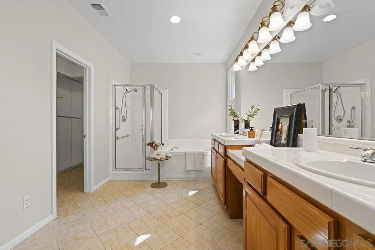 987 Palencia Court Chula Vista, CA 91910 - Photo 40 of 70 a spacious bathroom with a double vanity sink mirror and shower