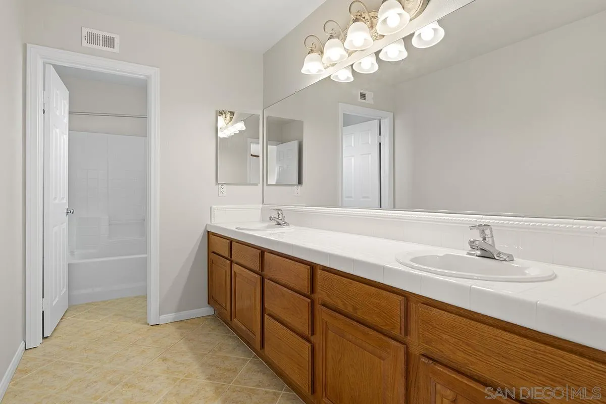 987 Palencia Court Chula Vista, CA 91910 - Photo 56 of 70 a bathroom with a double vanity sink and a mirror