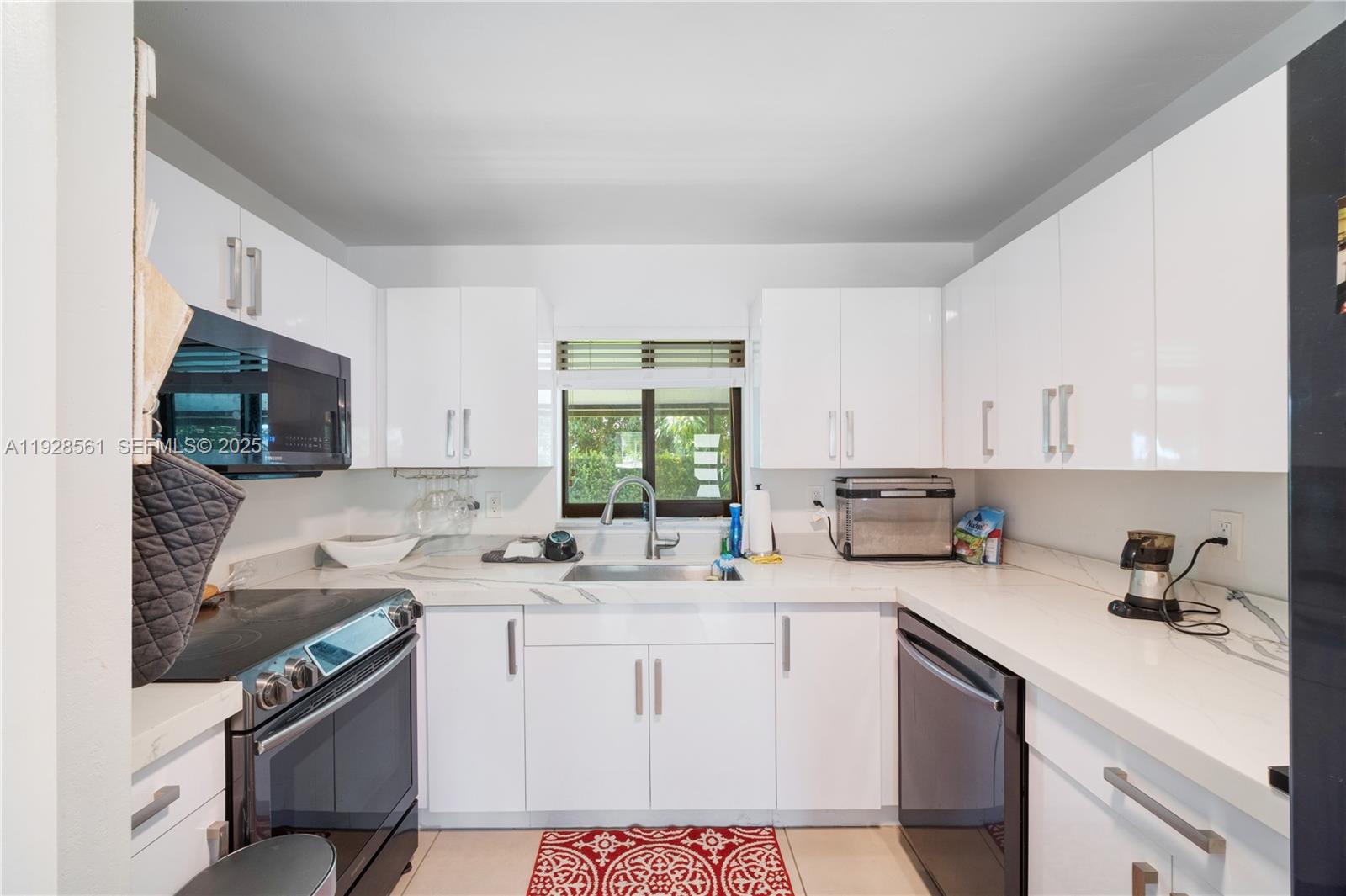 10350 Southwest 4th Street Sweetwater, FL 33174 - Photo 12 of 27 a kitchen with a sink stove top oven and cabinets