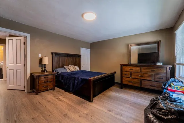 a bedroom with a bed and wooden floor