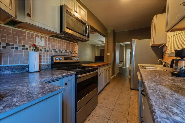 a kitchen with stainless steel appliances granite countertop a stove a sink and a microwave