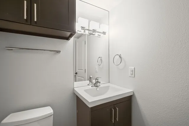 a bathroom with a sink a toilet and a mirror