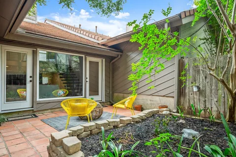 a view of a chair and table in backyard of the house