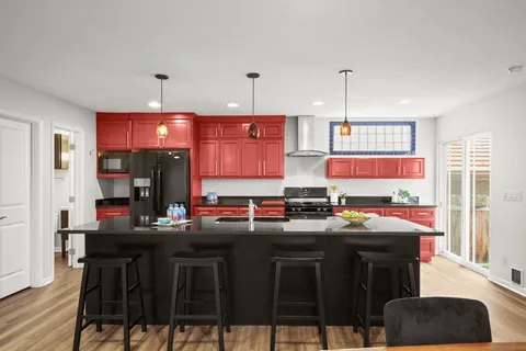 a kitchen with stainless steel appliances a stove a sink dishwasher and cabinets with wooden floor