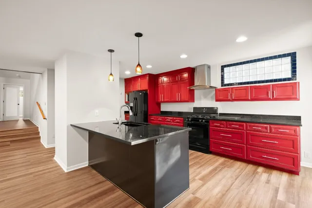 a living room with stainless steel appliances kitchen island granite countertop furniture and a fireplace