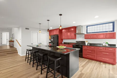 a kitchen with granite countertop a table chairs sink and wooden cabinets