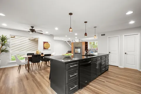 a kitchen with a sink and wooden floor