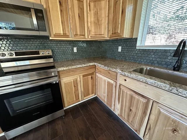a kitchen with granite countertop a stove and a sink