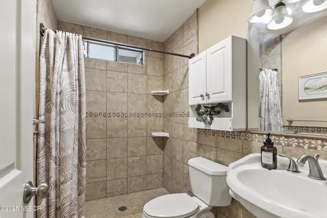 a bedroom with a bed and a flat tv screen on dresser