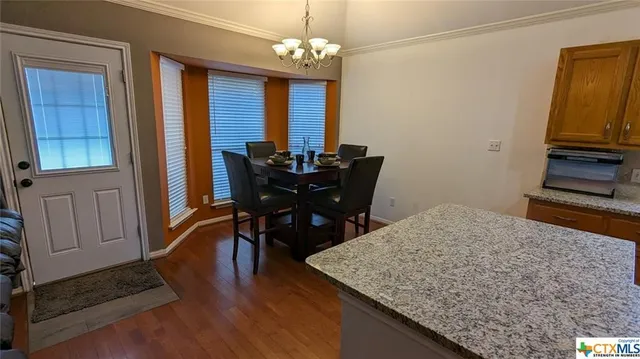 a view of a dining room with furniture and chandelier