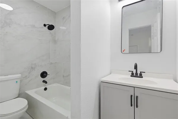 a bathroom with a toilet sink a mirror and bathtub
