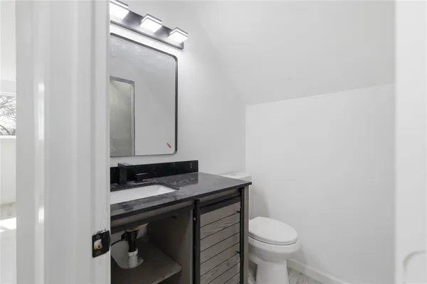 a bathroom with a sink a toilet and mirror