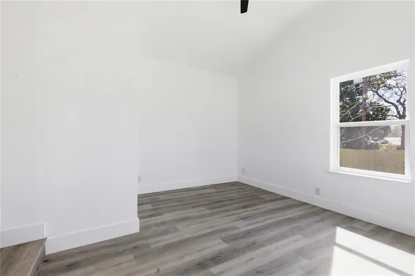 a view of a small space with wooden floor and a window