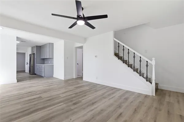 a view of a livingroom with wooden floor and a ceiling fan